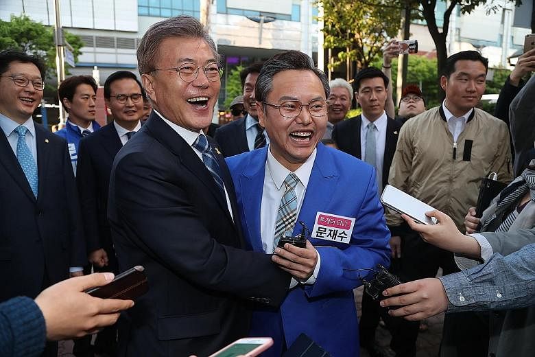 Far left: Mr Ahn Cheol Soo during a campaign stop in South Gyeongsang province last week. Left: Mr Moon Jae In (in dark jacket) with comic actor and impersonator Kim Min Kyo in Seongnam on Thursday.