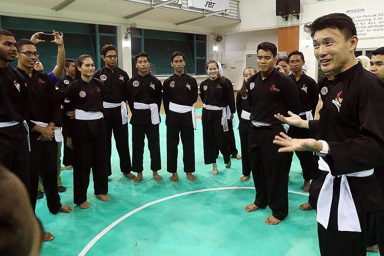 Parliamentary Secretary for Ministry of Culture, Community and Youth, Baey Yam Keng (right), donning silat attire while visiting the Singapore national silat exponents - led by world champion Shakir Juanda (centre) - as well as the national sepak tak