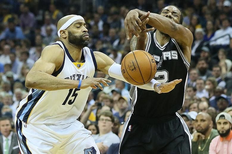 San Antonio Spurs' Kawhi Leonard has the ball knocked loose from his grip by the Memphis Grizzlies' Vince Carter. The Spurs forward led all scorers with 29 points as San Antonio put Memphis to rest 103-96, setting up a Conference semi-final showdown 