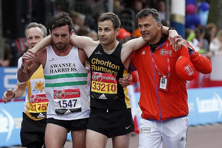 Matthew Rees of the Swansea Harriers (second left) helping the ailing David Wyeth of Chorlton Runners down The Mall to finish the London Marathon last Sunday. "I couldn't leave him there," Rees said, although other contestants ran past the stricken m