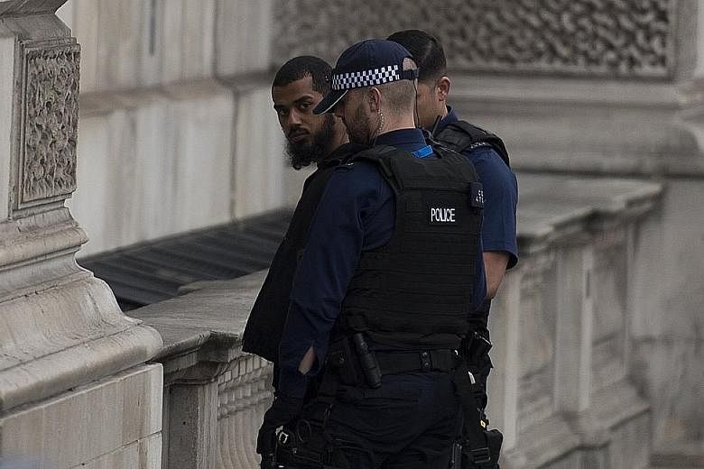 Police detaining a man suspected of carrying knives near Parliament in London on Thursday.