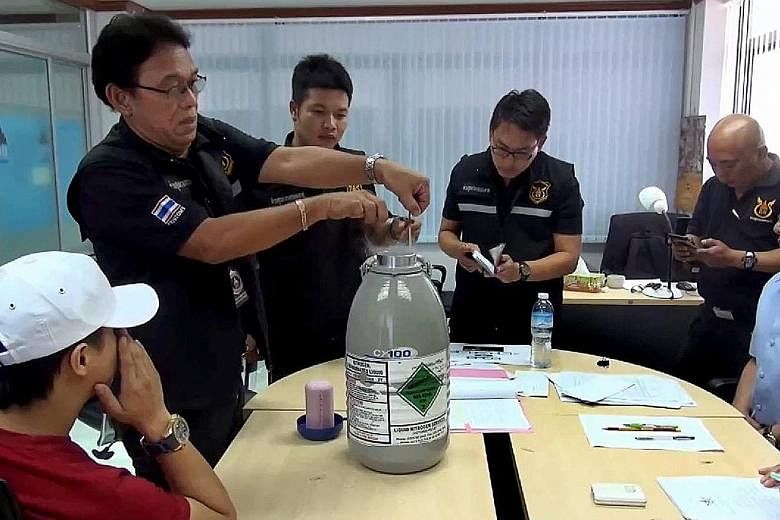 The Thai authorities with the nitrogen tank that was used to store the six vials of semen that a 25-year-old man attempted to carry into Laos.