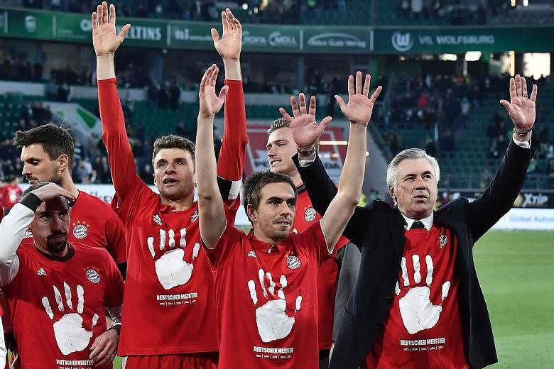 Bayern Munich manager Carlo Ancelotti (right) celebrating with players after winning the German Bundesliga title. The hand print on their shirts represents their five successive league wins from 2013 to 2017.