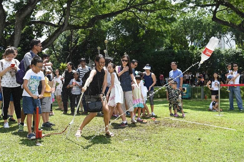 Clear skies and sunny weather greeted visitors to the Labour Day celebration at the Istana yesterday. Among the activities they got to enjoy was one involving firing rockets improvised from plastic bottles.