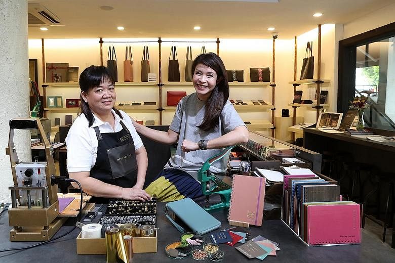 Bynd Artisan employee Tan Buay Heng (far left) with the firm's co-founder Winnie Chan. After working in her family's bookbinding firm Grandluxe for 20 years, Ms Chan launched Bynd Artisan in 2014 to move with the times. Five of Bynd Artisan's craftsm