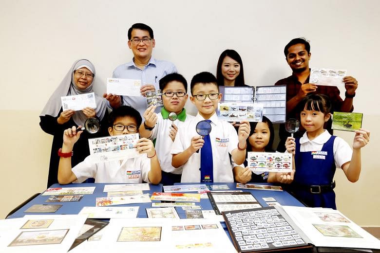 Mee Toh School principal Gau Poh Teck with teachers and pupils showing off their stamp collections. Mr Gau believes in using stamps to impart interesting details that would otherwise be quite dry in a textbook. 