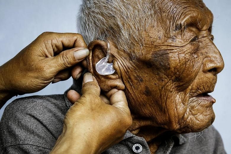 Mr Mbah Gotho getting some help with his hearing aid. The Indonesian claimed he was born in 1870.