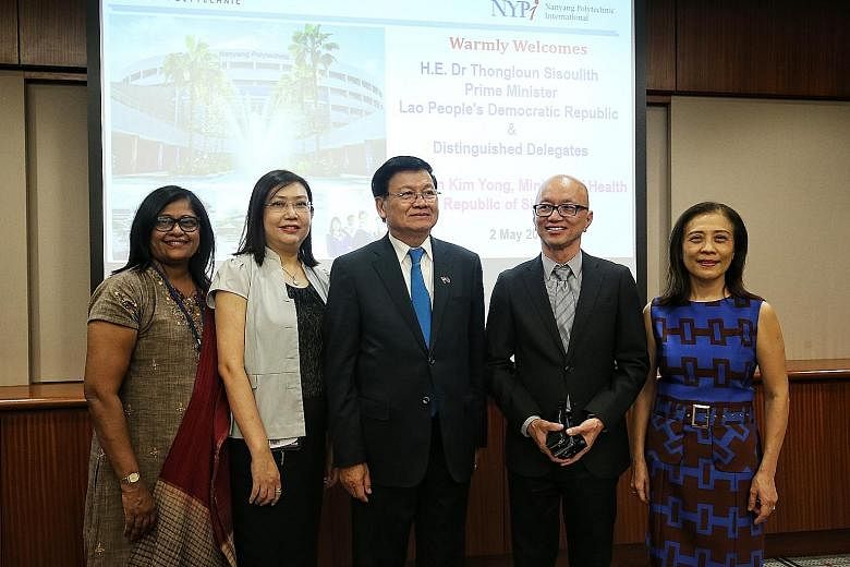 Laos Prime Minister Thongloun Sisoulith (centre) with four of his former teachers, (from left) Ms Sakunthalai Suppiah, Ms Angeline de Roza, Mr Lim Kok Hua and Ms Stephanie Chia, at Nanyang Polytechnic yesterday.