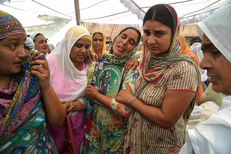 Ms Paramjeet Kaur, the mother of slain Indian Army soldier Paramjeet Singh, crying at his funeral ceremony in Vein Pein village, some 45km from Amritsar on Tuesday. India has accused Pakistan of killing two of its soldiers and mutilating their bodies