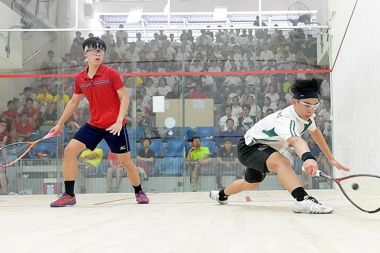 Raffles Institution's Aaron-Jon Liang (right) stretches to hit a backhand against Hwa Chong Institution's Regan Tan. He won 5-11, 11-4, 11-7, 8-11, 11-5 to seal the A Divison boys' squash title.