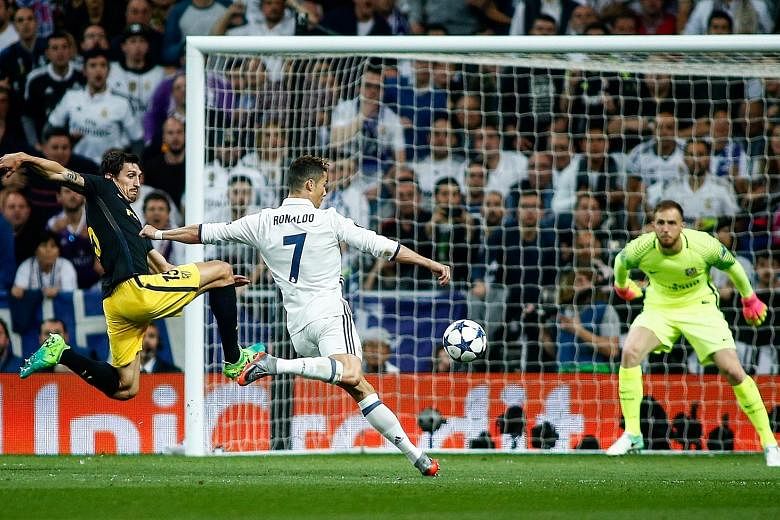 Real Madrid forward Cristiano Ronaldo shoots to score his second goal against Atletico Madrid in the Champions League semi-final first-leg clash at the Bernabeu as Stefan Savic fails to make a vital block.