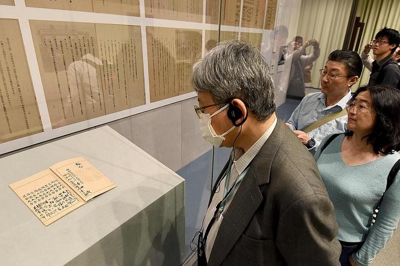 The original Japanese Constitution and its copies on the wall on display on Tuesday at an exhibition at the National Archives of Japan in Tokyo to commemorate the charter's 70th anniversary.