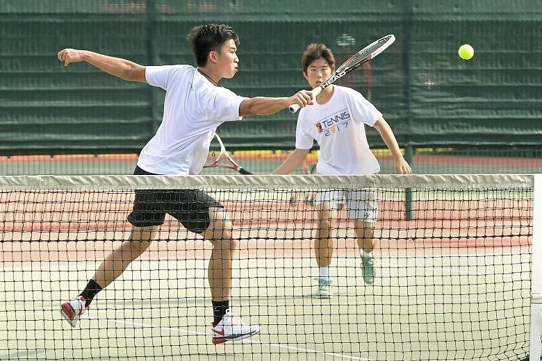Julian Cheng of Anglo-Chinese School (Independent) hitting a backhand volley as Joshua Tan looks on during the Schools National A Division tennis final. After a tie-breaker decided the first set, the pair went on to beat Ashton Tan and Wesley Wong of