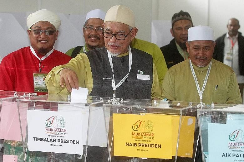 Parti Islam SeMalaysia president Abdul Hadi Awang (centre) at a polling booth in 2015. His plan of a new opposition grouping could be the swing factor that will decide the next government.