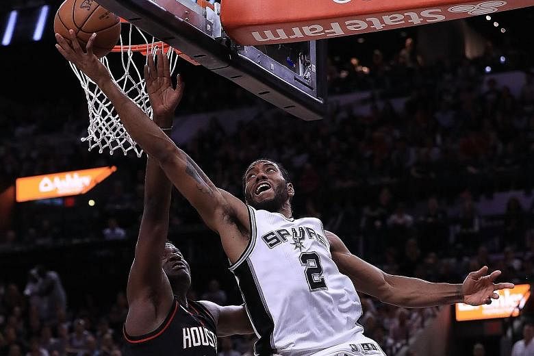 Spurs forward Kawhi Leonard goes up for a reverse layup as Rockets centre Clint Capela attempts to defend during Game Two.