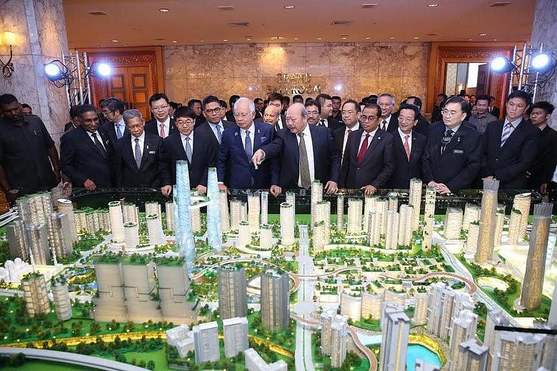 Tan Sri Lim Kang Hoo pointing out features on a model of Bandar Malaysia to Prime Minister Najib Razak last year. Unlike that project, many other deals with China have not even seen binding legal agreements, among them the Melaka Gateway port.