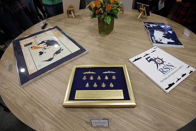 Items that will be in the time capsule include (from far left) a poster marking the ports of call during the Republic of Singapore Navy's first voyage around the world, the RSN's skill and vocation specialisation badges, a compilation of hopes and wi