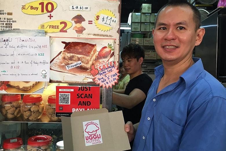 Mr Anton Tan set up the QR-code payment function yesterday at his Uggli Muffins stall in the Toa Payoh West Market and Food Centre. Looking for change can be time-consuming, he says, so he finds it quite useful.