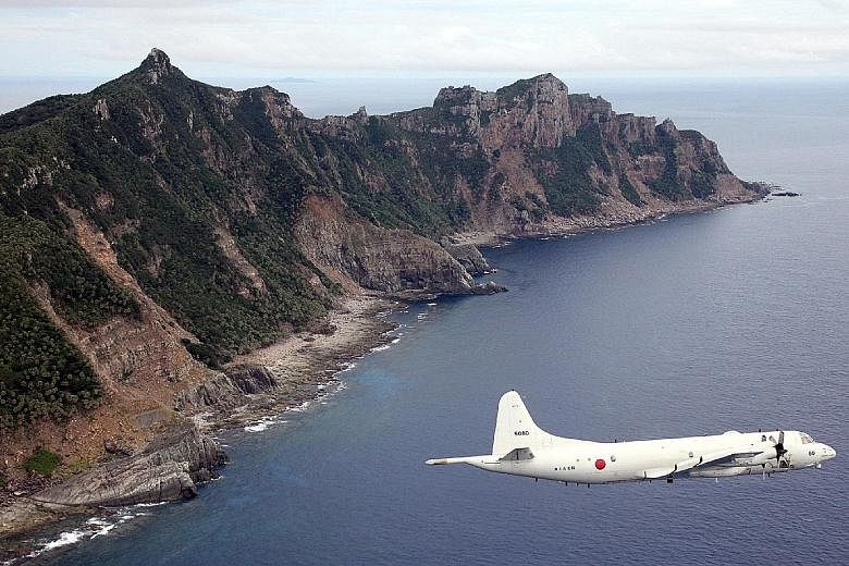 A P-3C patrol aircraft flying over one of the disputed East China Sea islets, known as Senkaku islands in Japan and Diaoyu islands in China. Japan is reportedly donating decommissioned P-3Cs to Malaysia.