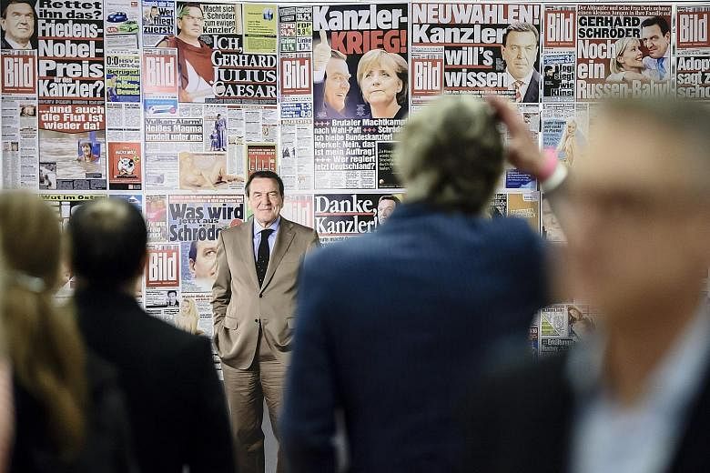 A photograph of former German chancellor Gerhard Schroeder looming large among other news photos from the German tabloid newspaper Bild during the opening of the exhibition Foto.Kunst.Boulevard in the Martin-Gropius-Bau exhibition hall in Berlin on T