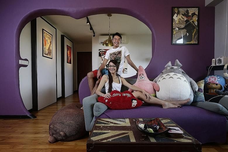 A purple wall with a curvy cutout (above) forms the entrance to the dining room in the home (right) of married couple Leon Luo and Gwen Chiong. A tree-inspired cement feature (above) acts as the backdrop for the television and lights; while a Bruce L