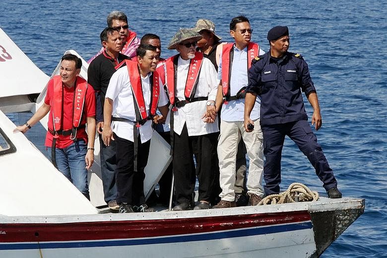 PAS president Abdul Hadi Awang (wearing a traditional hat) with Agriculture Minister Shabery Cheek (front row, second from right) on a boat in the waters off Terengganu on Thursday.