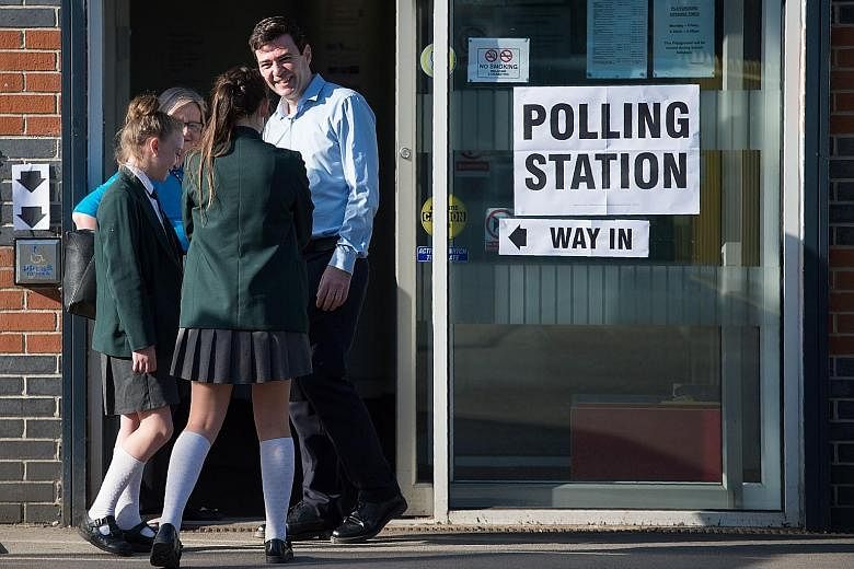Former Labour minister Andy Burnham with his two daughters at the polling station in Golborne Community Primary School near Warrington on Thursday, after casting his vote. He is standing as a candidate in the Greater Manchester mayoral election.