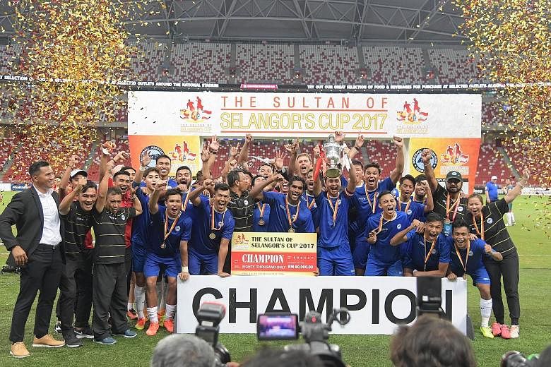 Left: The triumphant Singapore side with the Sultan of Selangor's Cup and their winners' medals after their 3-2 victory yesterday. It was Singapore's seventh win since the annual exhibition match began in 2001. Below: In the company of their player e