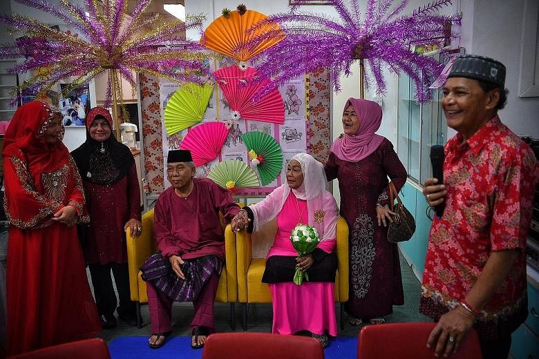 Newly-weds Mariah Abdul Hamid, 70, and Ismail Sapuan, 62, posing for photographs with their friends - (from left) Ms Zainab Ismail, 58, Ms Momin Jabar, 66, and Ms Kamaria Hussein, 59 - at the Sunlove Seniors Activity Centre in Chai Chee after the cou