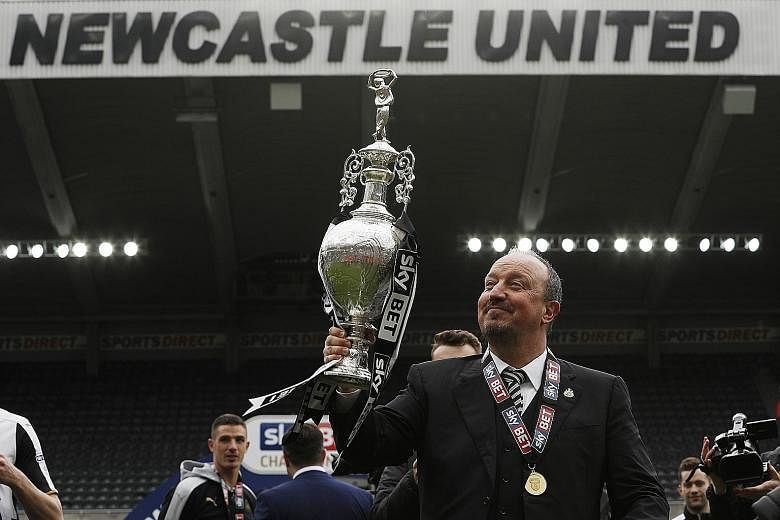 Newcastle manager Rafael Benitez celebrates winning the Championship trophy after his side finished a point above Brighton.