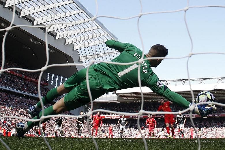 Southampton goalkeeper Fraser Forster dives to his right to keep out James Milner's penalty kick. Liverpool, who have failed to score against the Saints in four meetings this season, are third in the table with two games left.