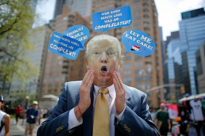 A man in New York wearing a Donald Trump mask taking part in the "100 Days of Failure" protest on April 29. The surprises from the Trump administration's first 100 days have been both positive and negative.