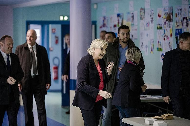Ms Marine Le Pen cast her vote in Henin-Beaumont, northern France. If she is able to get over 30 per cent, it would be seen as a major coup. A polling station in Marseille, southern France, yesterday. Turnout was 65.3 per cent by 11pm Singapore time,