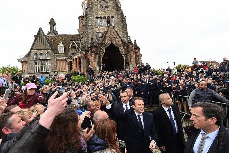 French presidential candidate Emmanuel Macron (centre) greeting supporters as he leaves after voting in Le Touquet, northern France, yesterday. Proponents of the European Union are rooting for Mr Macron, a former economy minister, against his far-rig