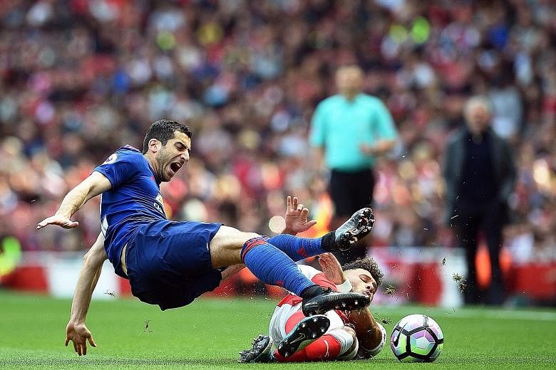 Manchester United's Henrikh Mkhitaryan (left) clashing with Arsenal's Alex Oxlade-Chamberlain during the Premier League match at the Emirates on Sunday. The match ended 2-0 in favour of the Gunners.