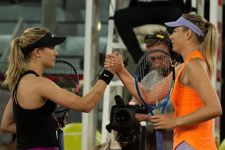Eugenie Bouchard (left) and Maria Sharapova exchanging a handshake at the end of their Madrid Open second-round match on Monday. Bouchard won the game 7-5, 2-6, 6-4.