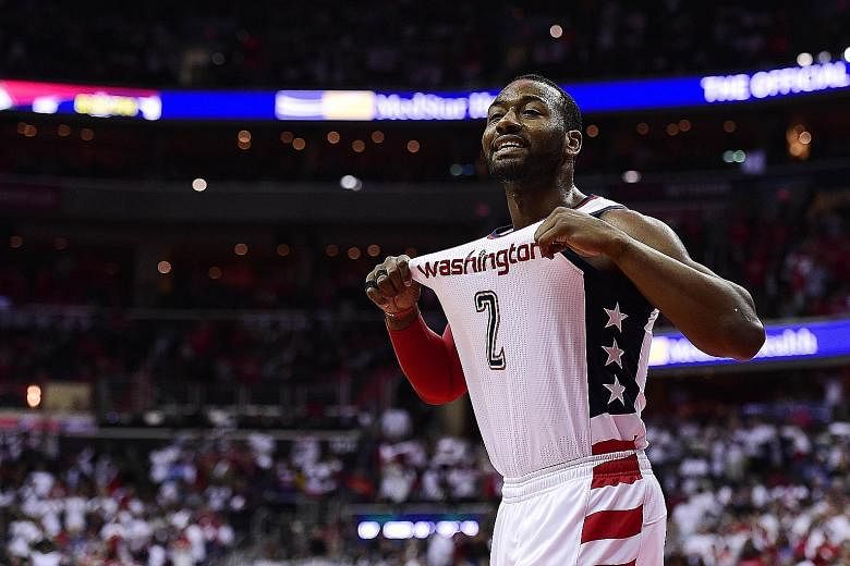 Washington Wizards' John Wall celebrating during the third quarter in Game Four of the Eastern Conference semi-finals against the Boston Celtics.