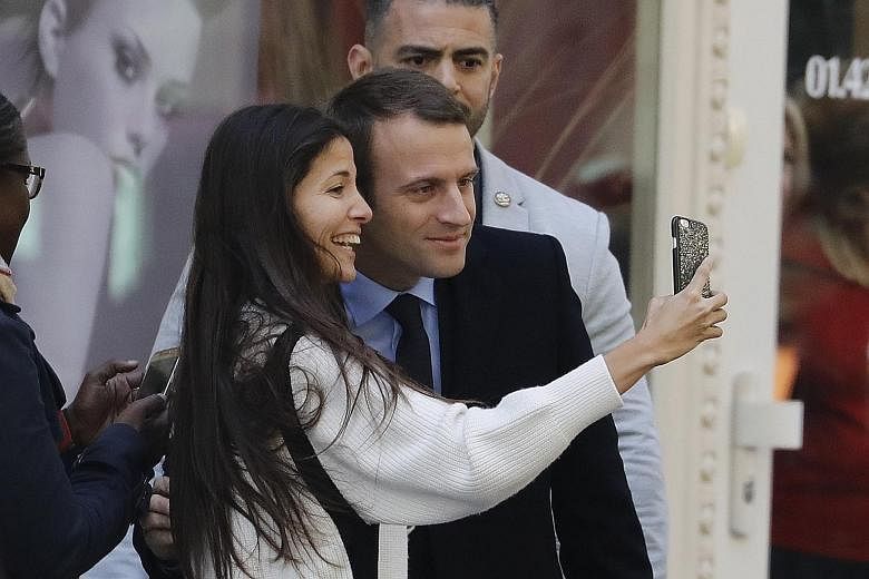 Mr Emmanuel Macron in a selfie moment with a delighted supporter after he defeated Ms Marine Le Pen in Sunday's French presidential election.