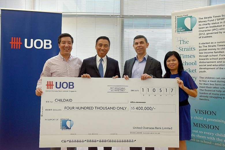 The Straits Times School Pocket Money Fund (STSPMF) received a $400,000 boost from the United Overseas Bank yesterday, from funds raised through its clients at an annual Chinese New Year dinner in February. Mr Eric Tham (second from left), managing d