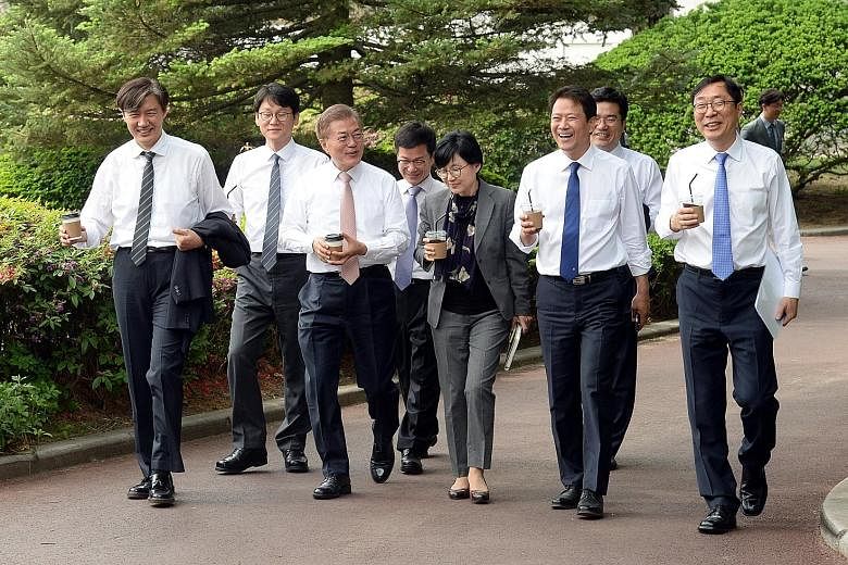 South Korean President Moon Jae In (third from left) with senior presidential aides at the Blue House in Seoul yesterday. The newly elected leader spoke on the phone with his Chinese counterpart Xi Jinping for 40 minutes yesterday. The two leaders ag