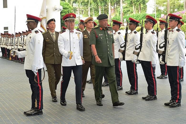 The Chief of the Malaysian Armed Forces, General Raja Mohamed Affandi Raja Mohamed Noor, inspecting a guard of honour at the Ministry of Defence yesterday as part of a three-day introductory trip to Singapore. He also met Defence Minister Ng Eng Hen 