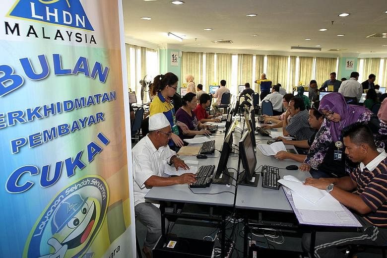People filing tax returns at the Inland Revenue Board in Kuching. The board has warned of stringent enforcement this year, with more auditing and probes to be carried out.