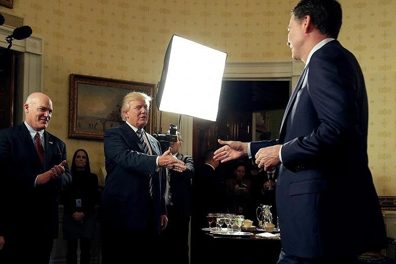 President Donald Trump and former FBI director James Comey in a January photo. Sources say Mr Trump grew increasingly agitated with Mr Comey's focus on the probe into Russia's links with the Trump campaign.