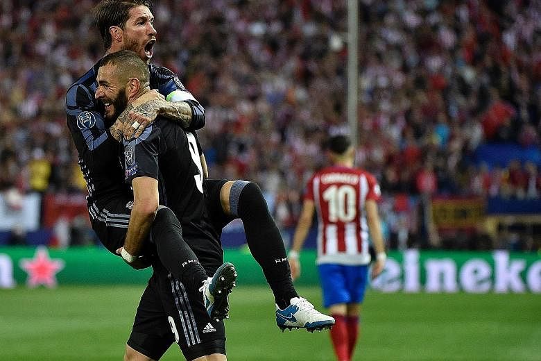Real Madrid forward Karim Benzema lifts team-mate Sergio Ramos off his feet as they celebrate their side's goal against Atletico Madrid in the Champions League semi-final second leg. Isco grabbed the away goal as Real progressed 4-2 on aggregate.