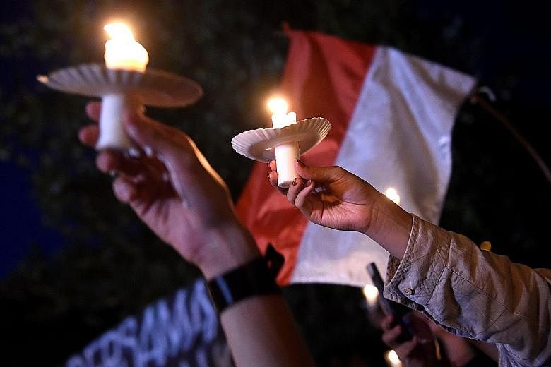 Supporters of Jakarta Governor Basuki Tjahaja Purnama, also known as Ahok, holding a candlelight vigil in Denpasar, Bali, on Thursday. The Christian-Chinese leader was sentenced to two years' jail for blasphemy.