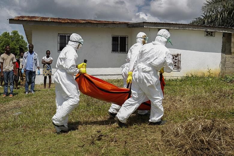 A burial team retrieving the body of a suspected Ebola victim in Banjor, on the outskirts of Monrovia, Liberia, in this October 2014 file photo. The Ebola flare-up that tore through West Africa in 2014 killed more than 11,000.