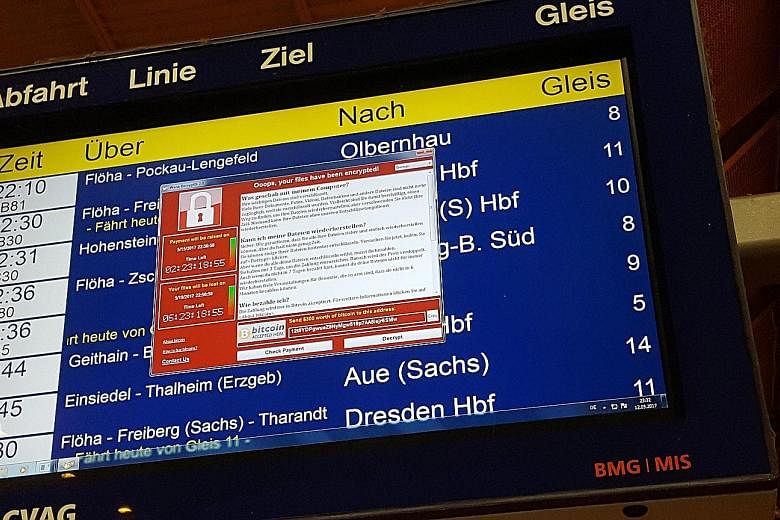 Above: A window announcing the encryption of data including a requirement to pay appears on an electronic timetable display at the railway station in Chemnitz, eastern Germany, last Friday. Left: The website of the NHS: East and North Hertfordshire n