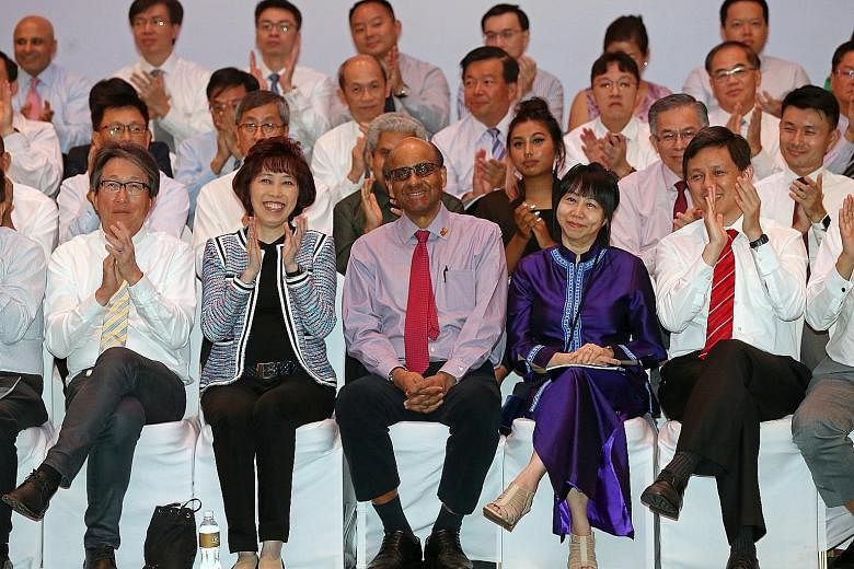 DPM Tharman Shanmugaratnam receiving an ovation after being presented the Medal of Honour for his contributions in improving the lives of workers at the NTUC May Day Awards ceremony yesterday. Beside him are (from left) Minister for Manpower Lim Swee