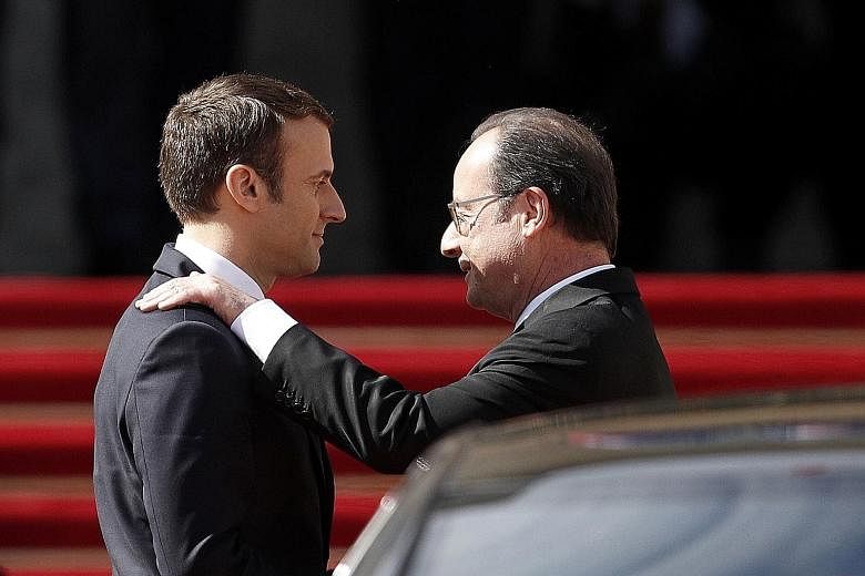 French outgoing President Francois Hollande (right) being escorted by his successor, Mr Emmanuel Macron, as he leaves the Elysee presidential Palace at the end of their handover ceremony yesterday.