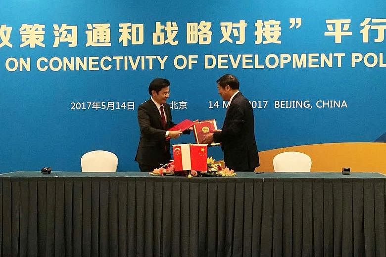Mr Lawrence Wong (far left) with Mr He Lifeng, head of China's National Development and Reform Commission, at the MOU signing yesterday.